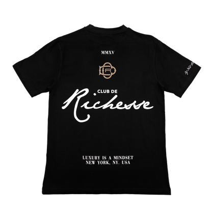 Back view of a black tee with refined embroidery detail on the sleeve and screen-printed details on the front and back, this tee delivers a balance of comfort, structure, and everyday wearability.
