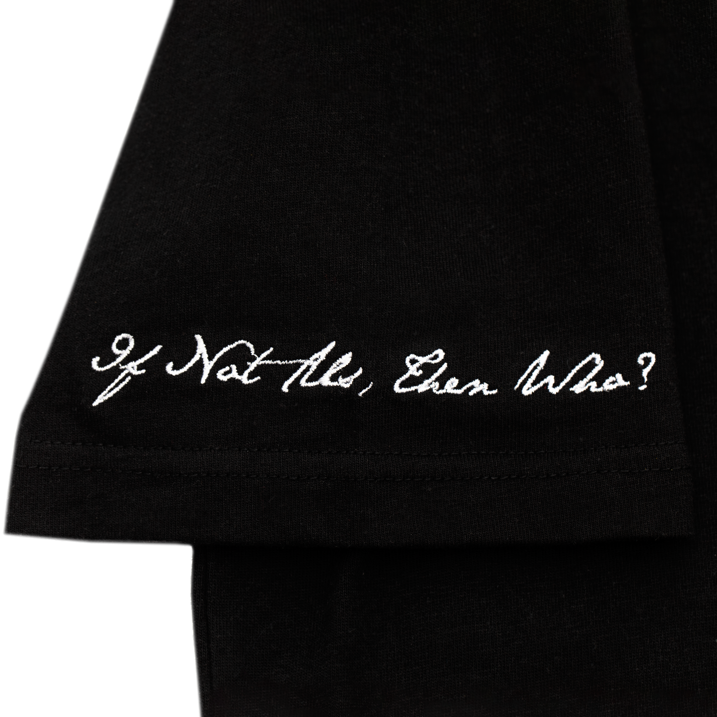 Arm close up view of a black tee with refined embroidery detail on the sleeve and screen-printed details on the front and back, this tee delivers a balance of comfort, structure, and everyday wearability.