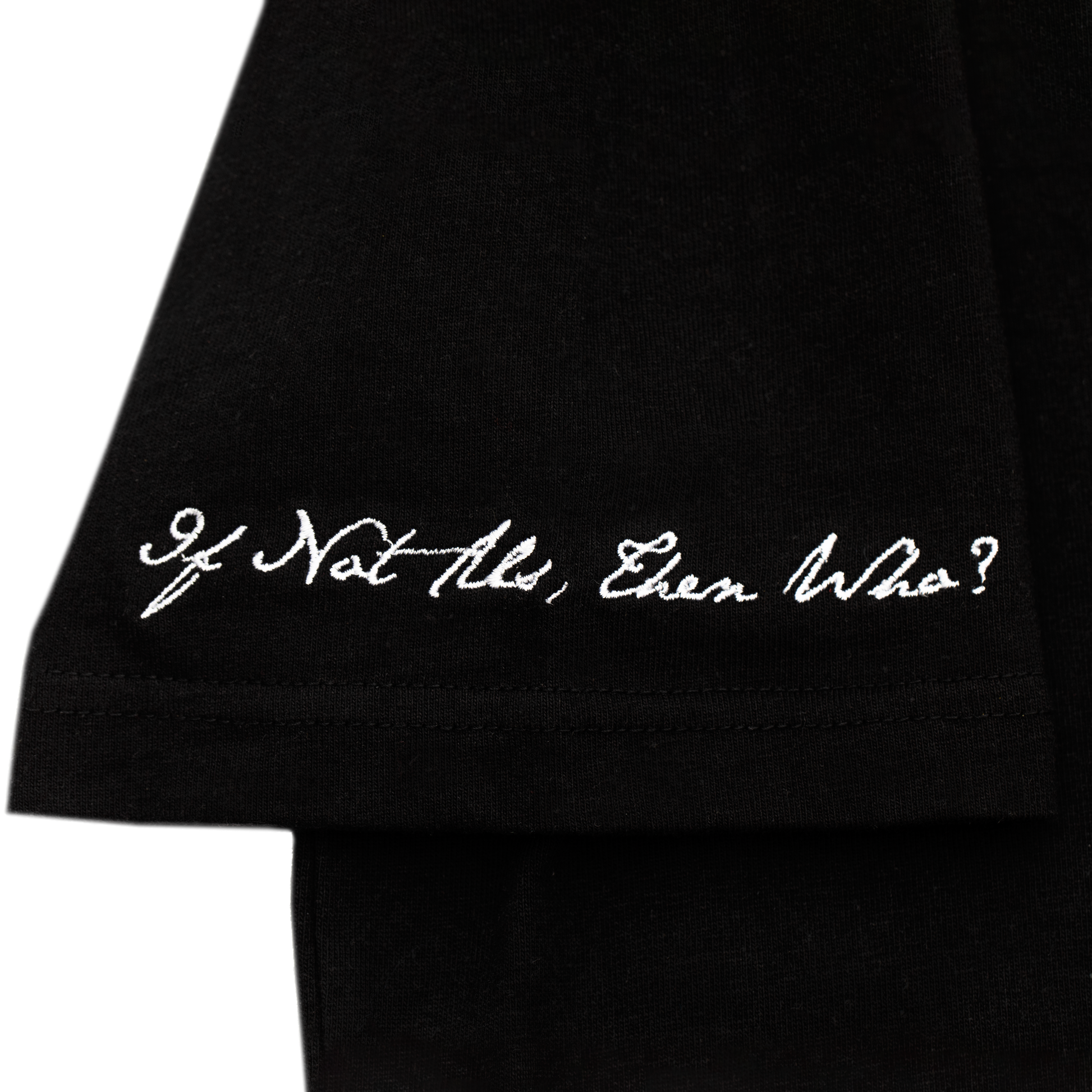 Arm close up view of a black tee with refined embroidery detail on the sleeve and screen-printed details on the front and back, this tee delivers a balance of comfort, structure, and everyday wearability.