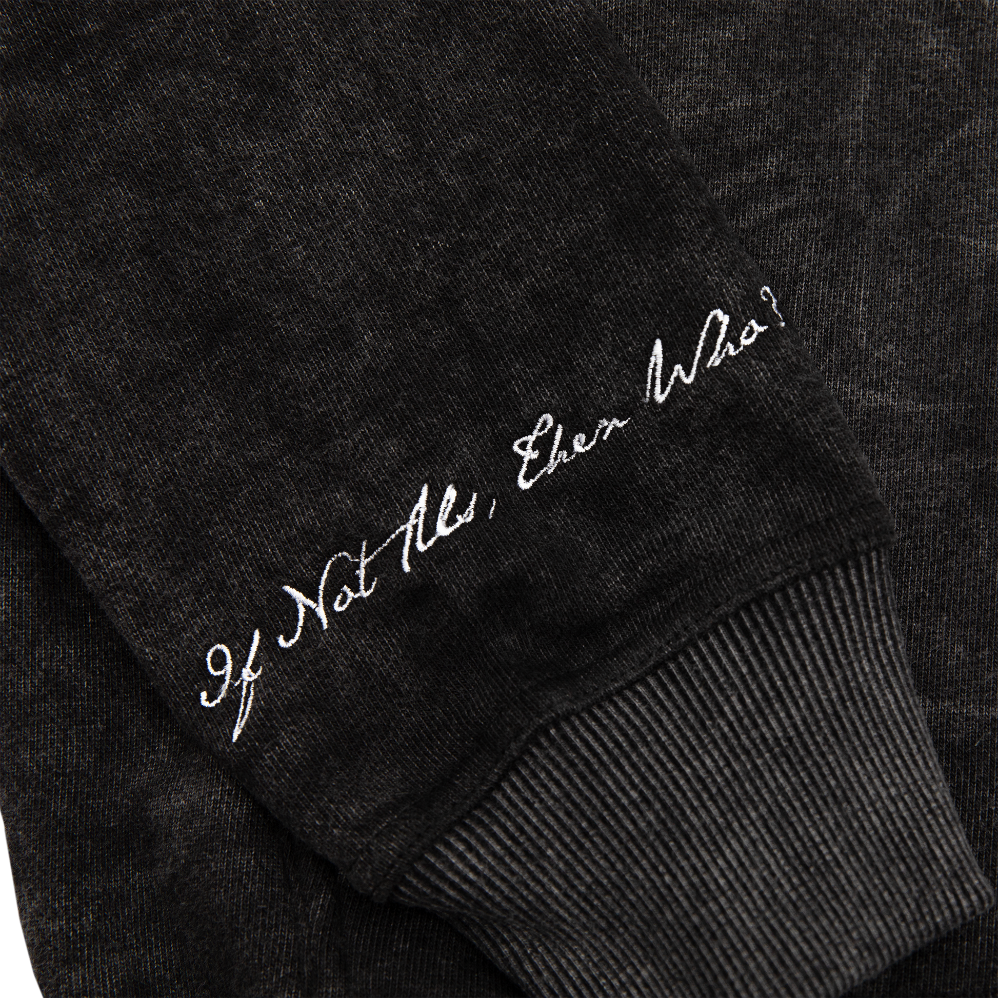 Sleeve close up view of an acid wash full-zip silhouette features elevated embroidery and screen-printed details on the front, balancing structure, comfort, and edge.