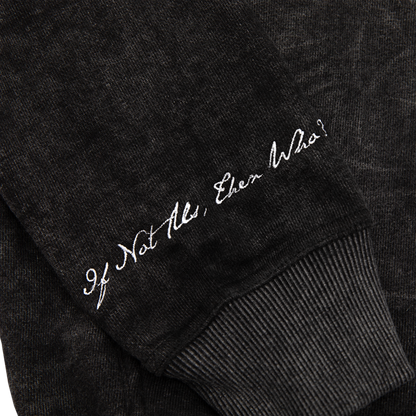 Sleeve close up view of an acid wash full-zip silhouette features elevated embroidery and screen-printed details on the front, balancing structure, comfort, and edge.