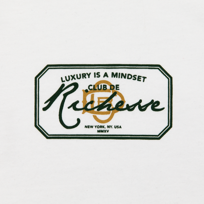 Chest close up  view of a white tee with refined embroidery detail on the sleeve and screen-printed details on the front and back, this tee delivers a balance of comfort, structure, and everyday wearability.